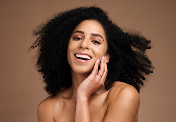 Image showing Woman, studio portrait and afro with beauty, makeup and cosmetic wellness with hands, face or natural hair. Model, skincare and facial cosmetics, self care glow and smile by brown studio background