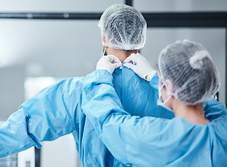 Image showing Doctor, uniform and theatre clothes for surgery, operation and medical healthcare. Nurse helping surgeon with safety scrubs, hospital ppe and emergency operating room in clinic for medicine teamwork