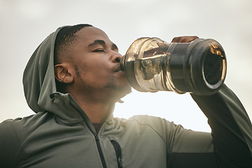 Image showing Fitness, health or black man drinking water after training, exercise or workout for body hydration. Thirsty runner, bottle or tired sports athlete relaxing with goals or motivation resting in Chicago