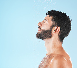 Image showing Water, cleaning and face with man and beauty, shower for hygiene and grooming with skincare against blue studio background. Clean, model profile with water drops and natural cosmetic treatment mockup