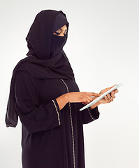 Image showing Woman, tablet and hijab of muslim for online islamic research against a white studio background. Female standing holding touchscreen with scarf reading news on islam, arabic or culture