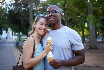 Image showing Happy, interracial and couple eating ice cream in a park on a date, anniversary or walk together. Love, smile and man and woman with a sweet dessert while walking in nature with romantic affection