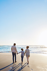 Image showing Family, beach and walk during sunset on vacation or holiday relaxing and enjoying peaceful scenery at the ocean. Sea, water and parents with daughter, child or kid with childhood freedom