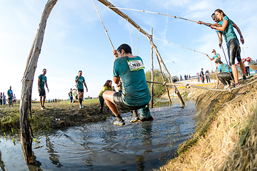 Image showing Athletes go through mud and water