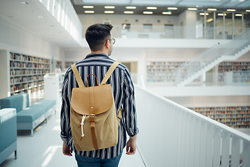Image showing Backpack, library and study with a man student walking in a university bookstore for education or learning. Back, college and research with a male pupil taking a walk in search of reading books