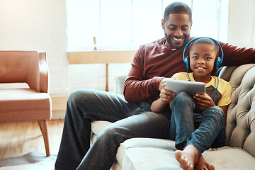 Image showing Tablet, sofa and father with his son watching a funny, comic or meme video on social media. Happy, smile and African man streaming a movie with his boy child on mobile device while relaxing together.