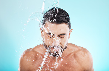 Image showing Man, water splash and face cleaning in blue background studio for grooming hygiene, skincare wellness and cosmetics dermatology care. Model, facial spa and body washing or morning beauty routine