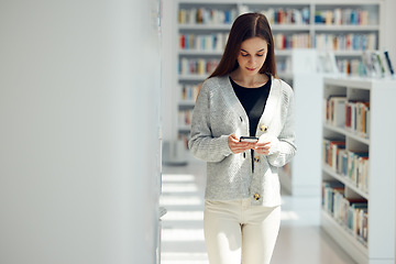 Image showing Phone, library and woman networking on social media, mobile app or the internet with mobile. Books, knowledge and young female student typing or reading a text message on her cellphone at university.