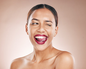 Image showing Makeup, beauty and lipstick on a woman with tongue on teeth for cosmetics on a studio background for dermatology, color and salon mockup. Face of aesthetic model with a smile, glow and healthy skin