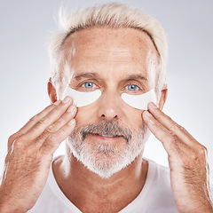 Image showing Senior man with collagen eyes mask in skincare, dermatology facial and face cosmetics advertising in studio portrait. Elderly model with hands application of eye patch, anti aging product and beauty
