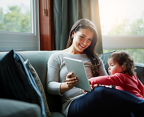 Image showing Mother, tablet and baby playing on sofa in living room for entertainment, bonding or time together at home. Happy mom with cute little daughter, child or kid relaxing on the couch with touchscreen