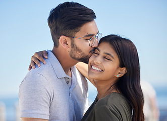 Image showing Love, blue sky and couple hug, kiss and enjoy outdoor quality time together on romantic summer vacation date. Ocean beach, freedom peace and man and woman bond on travel holiday in Miami Florida USA