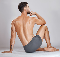 Image showing Fitness man, body muscles and back on studio background for bodybuilding, workout training goals or exercise wellness. Underwear model, bodybuilder and strong person on gray backdrop for healthcare