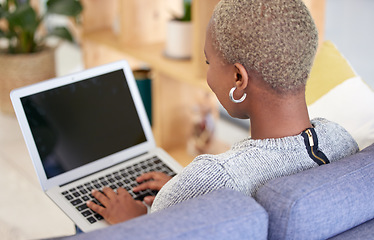 Image showing Black woman, blank laptop screen and relax on sofa for marketing mockup, online advertising and digital communication in home. African woman, typing on keyboard and empty web homepage for connection