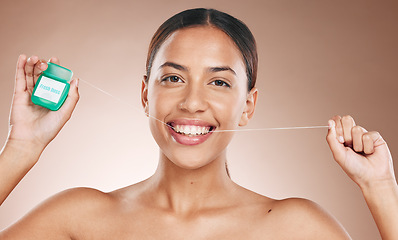 Image showing Woman cleaning teeth with dental floss, portrait of girl with happy smile and studio with brown background. Oral hygiene with healthcare product, cosmetic maintenance for healthy mouth and flossing