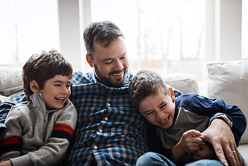 Image showing Bonding, hug and father with children on the sofa for love, care and relax in their family home. Happy, funny and dad with boy kids for quality time, affection and comedy on the couch of a house