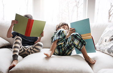 Image showing Kids, boys or reading books for education, learning or relax studying on house living room or home sofa. Children, storytelling and fantasy fairytale novel in hobby activity or creative inspiration