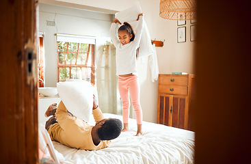 Image showing Pillow fight, home and family bonding with a father and child having fun in a bedroom. Happiness, love and parent care of a dad with a young girl in the morning happy and play fighting on a bed