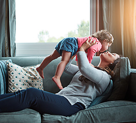 Image showing Relax, happy and kiss with mother and baby on sofa for bonding, quality time and child development. Growth, support and trust with mom and daughter in family home for health, connection and care