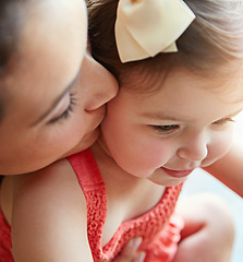 Image showing Mother kissing her girl baby on her cheek while playing, bonding and spending time together. Happy, smile and girl infant child sitting with her mom in their modern family home with love with care.