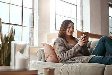 Image showing Happy, woman and phone for social media on a sofa, texting and chatting on dating app in her home. Girl, smartphone and text conversation in a living room, smile and relax while streaming and resting