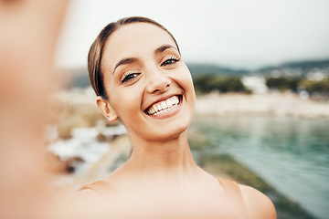 Image showing Selfie, beach and travel with a woman tourist taking a picture outdoor during summer vacation or holiday. Portrait, face and smile with an attractive young female happy on the coast by the sea