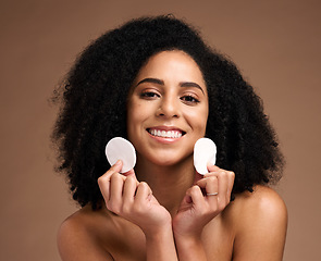 Image showing Skincare, face portrait and black woman with cotton in studio isolated on a brown background. Cosmetics, wellness and happy female model holding facial pad or product for cleaning makeup for hygiene.