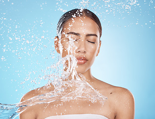 Image showing Woman face, skincare grooming or water splash on blue background studio in dermatology wellness, healthcare cleaning or Brazil hygiene maintenance. Beauty model, wet or water drop for facial cleaning