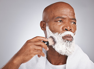 Image showing Face, shaving cream and black man with brush on beard, skincare spa treatment on grey background. Health, mock up and facial hair, mature man morning shave routine with space for product placement.