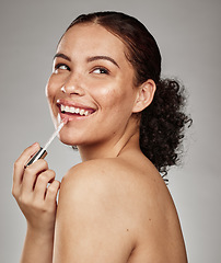 Image showing Woman, lipstick and beauty makeup cosmetics for skincare or glow against a grey studio background. Happy female smiling with teeth in satisfaction for lip, mouth and applying cosmetic treatment