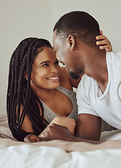 Image showing Black couple, love and home bedroom bonding while happy together on a bed in a house, apartment or hotel. Young man and woman intimate in a healthy marriage with commitment, happiness and care