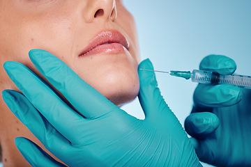 Image showing Botox, hands and cosmetic surgery with a woman and doctor in studio on a blue background for face change. Beauty, skin and injection with a surgeon holding a syringe for female client facial filler