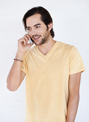 Image showing Phone call, talking and man in studio, happy and relax while standing on white background space. Young, phone and hand guy enjoying casual call, conversation and speaking while chilling and isolated