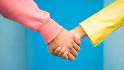 Image showing Couple, love and holding hands together for support care, relationship and bonding in blue background studio. Man, woman and hand for partnership, romance trust and solidarity or compassion lifestyle