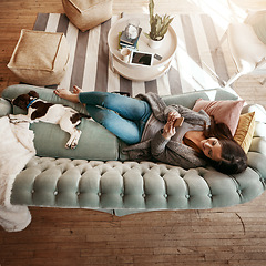 Image showing Woman relax on couch with phone, social media scroll and communication at home, contact and technology. Happy woman, smile for meme and web search with streaming, smartphone and rest on sofa top view