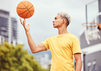 Image showing Sports, fitness and man spinning basketball on court outdoors before workout, exercise or practice. Basketball court, balance and young male player with ball on finger getting ready for training.