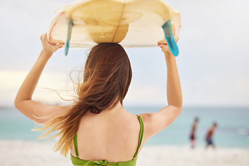 Image showing Beach, fitness or woman with surfboard, freedom or calm peace watching the relaxing ocean waves on holiday vacation. Travel, back view or healthy girl athlete thinking of surfing goals or training