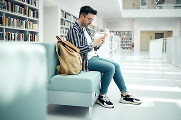 Image showing Library, university and man with phone on sofa for education, research and checking social media. Networking, knowledge and male student on smartphone, mobile app and website in college bookstore