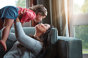 Image showing Relax, happy and kiss with mother and baby on sofa for bonding, quality time and child development. Growth, support and trust with mom and daughter in family home for health, connection and care