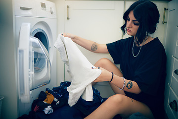 Image showing Laundry, cleaning and housework with a woman using the washing machine in her home for domestic responsbility. Appliance, fabric and clothes with a female cleaner on her apartment floor to wash