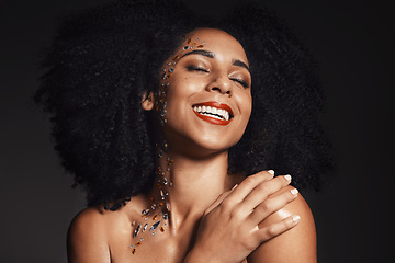 Image showing Woman rhinestones, face or body art jewels on black background studio in fashion sparkle, festival accessory or creative party crystals. Happy smile, afro or beauty model skin or makeup cosmetic gems