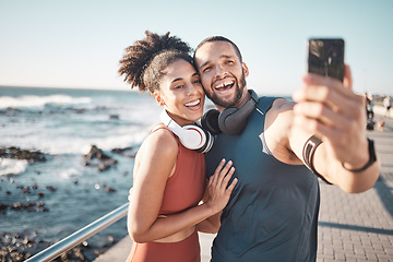 Image showing Fitness, couple and phone in beach selfie with smile for running, exercise or workout in the outdoors. Happy man and woman smiling in happiness looking at smartphone for photo after run by the ocean