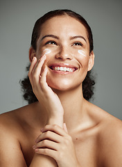 Image showing Skincare, beauty and dermatology woman with cream for acne, health and glow on a studio background. Spa, sunscreen and model thinking of a cosmetics product for anti aging and facial wellness