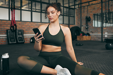 Image showing Woman, fitness and phone at gym for a workout, training and body wellness with a mobile app. Young sports female with smartphone for progress, performance and communication for a healthy lifestyle