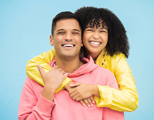 Image showing Couple, smile and hug in portrait with happiness, love and commitment with fashion isolated on blue background. Interracial relationship, commitment and together in studio with happy people and trust