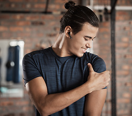 Image showing Arm, shoulder muscle hold and man in a exercise, fitness and wellness gym happy about target goal. Sports, athlete and healthy young person with a smile after training and workout in a health club