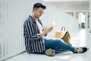 Image showing Man, student and reading with glasses and book for knowledge, education or learning at university. Male learner in library with books for thesis, project or assignment for scholarship at the campus