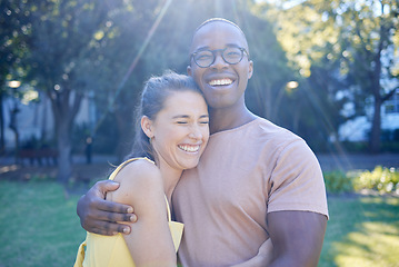 Image showing Happy interracial couple, hug and laughing in joy for bonding relationship together in the park. Man hugging woman smiling in happiness for love, embrace and sharing a laugh for funny joke in nature