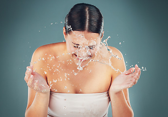 Image showing Beauty, water splash and washing face for skincare, cleaning and dermatology on a studio background. Health and wellness of a aesthetic model person cleaning skin or body for facial spa treatment