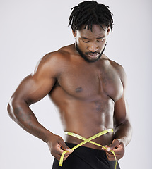 Image showing Tape, fitness and man body isolated on white background for lose weight, bodybuilder diet and training wellness. Bodybuilding, studio and sports black person measure his waist, stomach or muscle